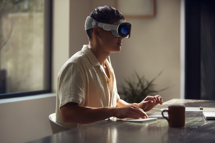 Man using virtual workstation while wearing the Apple Vision Pro VR/AR headset.
