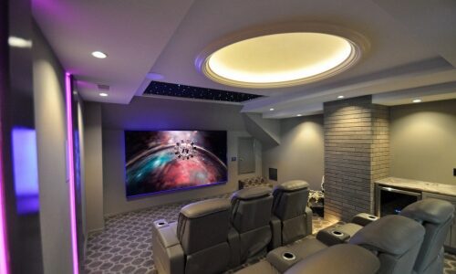 Interior of family-friendly entertainment room in converted attic space. Home theater design by Theater Advice