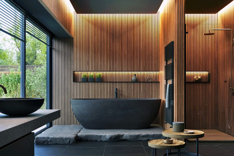 Interior bathroom with ample accent lighting over a black stone bath tub.